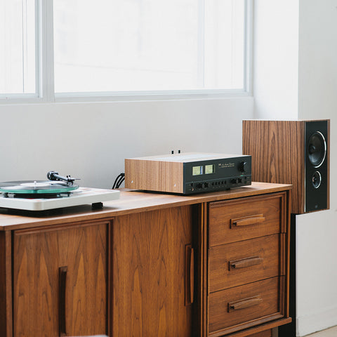 NAD C3050 Amplifier on a credenza beside a turntable and PSB Synchrony B600 Speaker