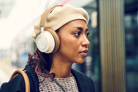 Woman wearing IO-8 Headphones in Caramel White while walking