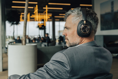 Man wearing DALI IO-12 headphones in dark chocolate finish in airport