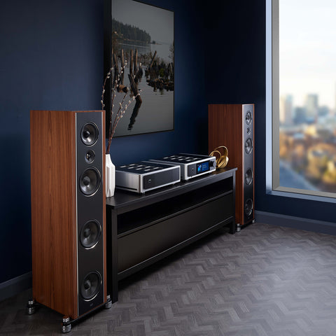 NAD M23 power amplifier and NAD M33 on a credenza in between PSB Synchrony Tower Speakers