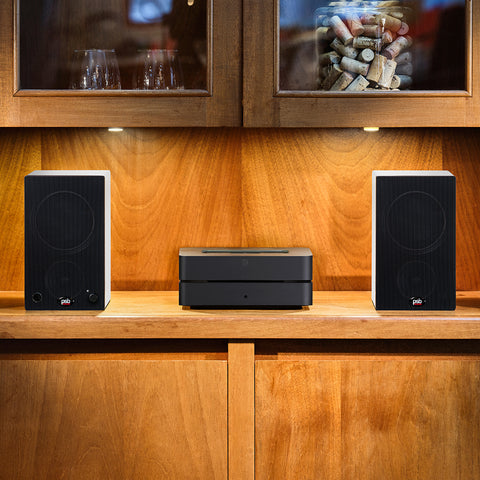 Alpha AM3 White with grille on shelf with Bluesound Vault 2i