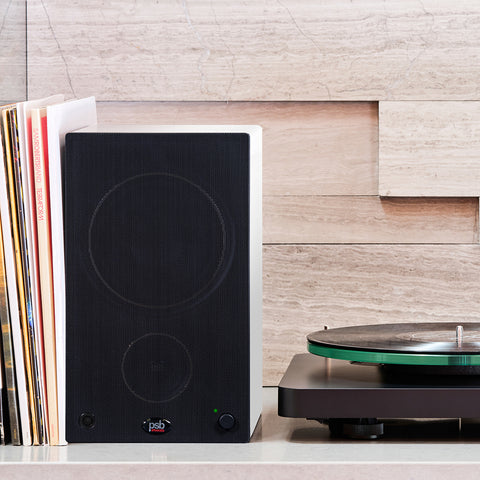 PSB Alpha AM5 White with grille on shelf with NAD Turntable