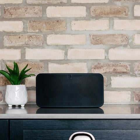Bluesound Pulse Mini 2i Black on a credenza