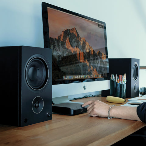 Bluesound Node Nano on desk hooked up to PSB AM5 Speakers