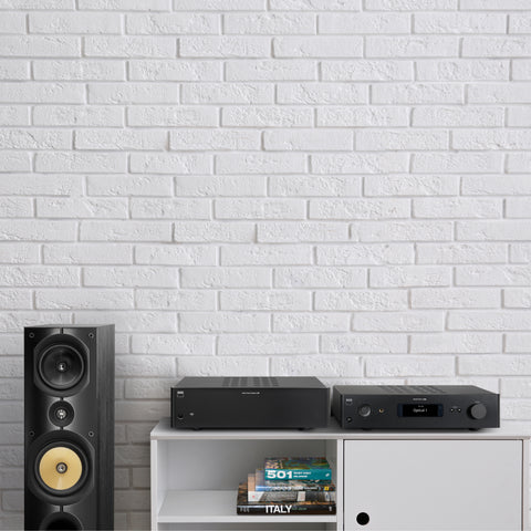 NAD C298 Power Amplifier beside an NAD C658 Streamer on a credenza beside PSB Imagine X2T Tower Speaker