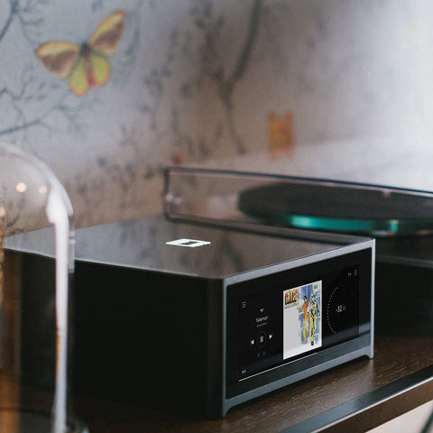 NAD M10 V3 on credenza beside a turntable