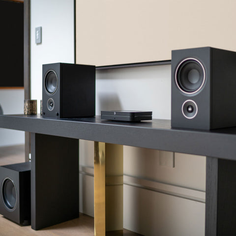 PSB Alpha AM5 Black without grille on shelf with Bluesound Node
