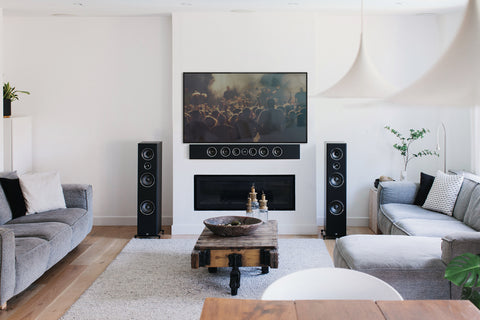 Black PSB Imagine series speakers in a living room