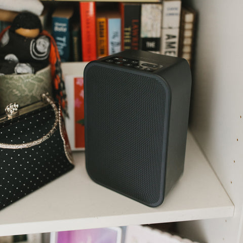 Bluesound Pulse Flex 2i Black on a shelf in front of books