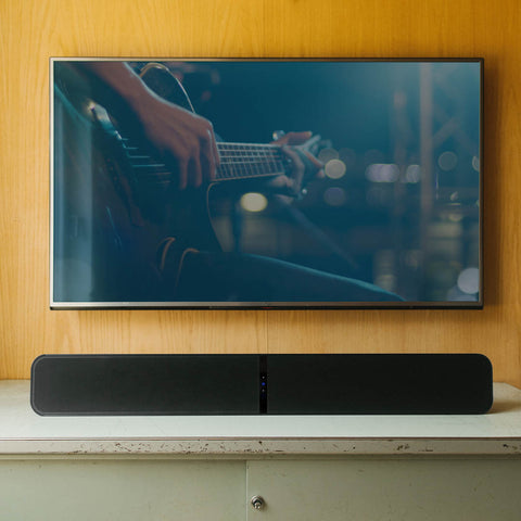 Bluesound Pulse Soundbar Plus Black on entertainment unit below a TV