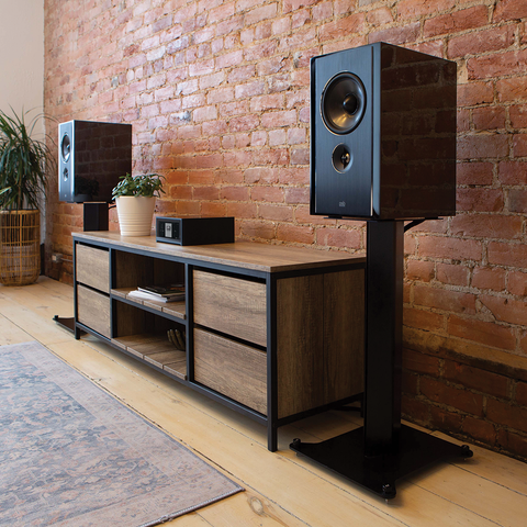 PSB Synchrony B600 high gloss black bookshelf speakers on either end of a credenza with an NAD M10 V2 amplifier