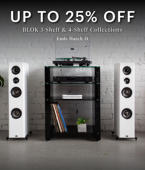 Home audio system with speakers and Black BLOK shelves against a white brick wall, promotional text overlay. Up to 25% off 3-shelf and 4-shelf collections. Ends March 31.